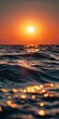 A sunset over the ocean with waves and sun.