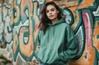 urban chic young woman in green hoodie against graffiti wall clothing mockup