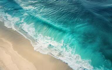 Aerial view of turquoise ocean waves meeting sandy shore.