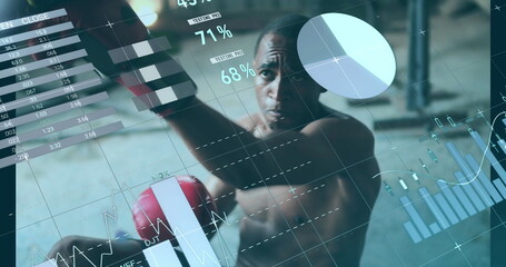 African American athlete training with boxing gloves, digital graphs overlaying