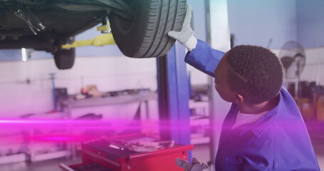 Poster - Image of light trails over african american male mechanic reapiring car