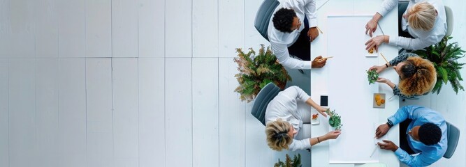 Wall Mural - Top view of a business team working together at a table with an empty white banner for copy space, taken
