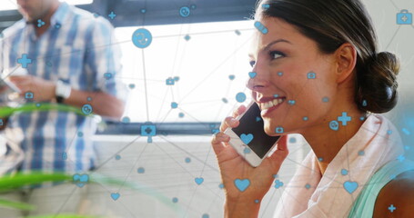 Poster - Image of icons connected with lines over smiling caucasian woman talking in cellphone at office