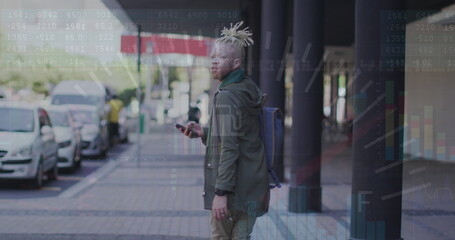 Poster - Image of graphs, numbers on african american man with cellphone looking back and walking in city