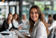 © PixelStock - businesswoman smiling while holding a tablet in an office with a team working at a table