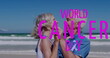 Image of world cancer day over happy caucasian senior couple dancing on beach