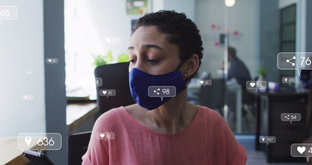 Poster - Image of social media icons with numbers over biracial businesswoman wearing face mask