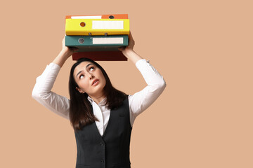 Canvas Print - Businesswoman with folders on beige background