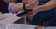 Image of data processing over mid section of man using smartwatch to make payment at a cafe