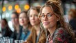 © Vilaysack - Close-up portrait of a beautiful woman with glasses smiling in a restaurant with friends in the background