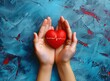 Top view of two hands holding a red heart with a pulse line, a health care concept.