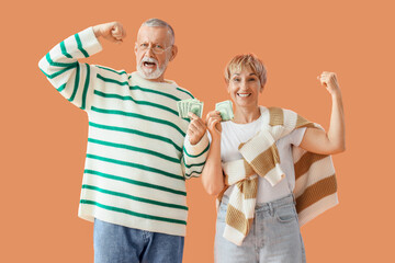 Poster - Happy mature couple with money on orange background