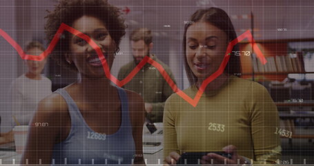 Sticker - Image of changing numbers and red graph against two diverse women discussing at office