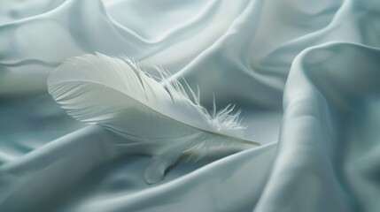 Wall Mural - A mesmerizing scene featuring a single, delicate white feather resting with grace on a smooth, soft fabric surface