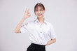 Pretty Asian woman in university student uniform make OK hand signal over isolated white background.