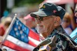 © evgenia_lo - Elderly Caucasian veteran wearing a military cap and sunglasses, holding an American flag at a parade. 4th of July, american independence day, happy independence day of america , memorial day concept
