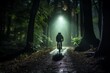 © Dadee - A cyclist rides through a dark forest at night. The only light comes from the cyclist's headlamp.