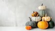 Pumpkins stacked for fall decor on white surface