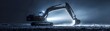 © nitiroj - Nighttime scene of an excavator illuminated by spotlights, casting long shadows and creating a dramatic effect on a white background