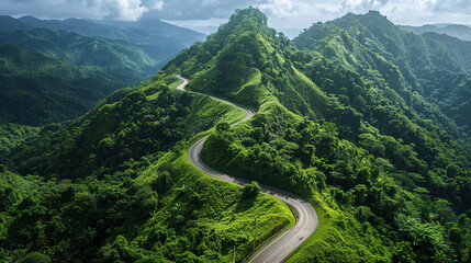A winding mountain road surrounded by lush green forests on a sunny day