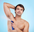 Grooming, man and deodorant in morning, routine and wellness in body care, hygiene and blue background. Male person, cosmetics and fresh for confidence, masculine and fragrance with product in studio