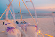 Idyllic table setup wedding ceremony on sunset beach. Romantic destination dining, couple anniversary romance celebration. Love arrangement togetherness dinner on island shore. Amazing sky sea view