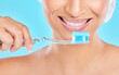 Hands, studio or happy woman brushing teeth with dental toothpaste for healthy oral hygiene. Product, fresh or face of girl cleaning mouth with brush for smile closeup or wellness on blue background