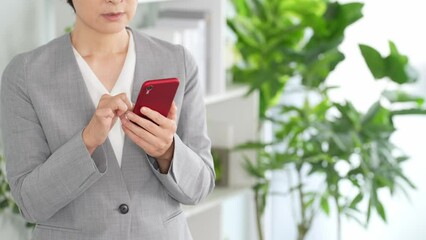 Leinwandbilder - オフィスでスマホを使う女性ビジネスパーソン