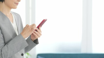 Leinwandbilder - オフィスでスマホを使う女性ビジネスパーソン