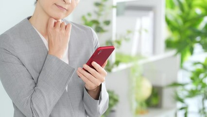 Poster - オフィスでスマホを使う女性ビジネスパーソン