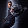 Man, serious and fashion or dark studio, spy and coat with wind for escape and looking. Classy, semi formal and outfit on black background, male model and Indian person with trendy winter clothes