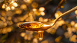 Honey on a spoon with flowers in the background.
