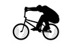 silhouette of boy showing off freestyle trick with bicycle