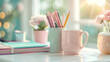 Pens and pencils in pastel colors inside a mug on the desk.