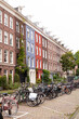 row of bicycles parked on street in front of Dutch homes