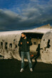 Man stand near the abandoned plane on Sólheimasandur in Iceland.