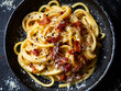 A plate of pasta with bacon and parmesan.