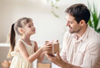 © tiena - Happy little daughter gives a gift to her dad. Father's day cele