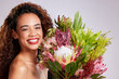 Woman, flowers and happy portrait in studio for skincare, haircare and organic beauty on white background. Brazil female person, bouquet and smile for wellness, summer and curly hair or romantic gift