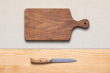Canvas Print - Handmade walnut wood cutting board and knife lie on the table. cutting board with knife. cutting board and knife.