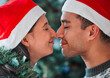 Love, nose kiss and couple at Christmas in home for festive party or celebration together. Happy, romance and young man and woman with sweet bonding moment for mistletoe at xmas holiday at house.