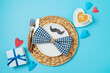 Table setting for Father's day breakfast with heart shape coffee cup, plate and gift box on blue background. Top view, flat lay