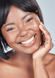 Black woman, portrait and happy face with skincare, cosmetics or makeup on a gray studio background. Closeup of African, female person or young model for facial treatment, dermatology or cosmetology