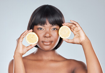 Skincare, portrait or black woman in studio with lemon for wellness, shine or dermatology glow treatment on grey background. Face, cleaning or girl model with fruit for citrus, benefits or skin detox