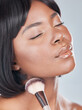 Makeup, brush and calm black woman in studio with cosmetic, product and application on grey background. Beauty, glow and African girl model with cheek powder tools for facial, contour or aesthetic