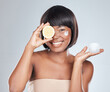 Happy, portrait and black woman with lemon and container for skincare, cream or moisturizer on a white studio background. African, female person or model with smile for vitamin C, facial or collagen