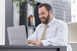 Office, business and man with laptop, typing and thinking with internet, communication and connection. Person, employee and consultant with computer, technology and website info with happiness or joy