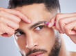 Beauty, face and man with tweezers in studio for eyebrow, shape and hygiene, grooming or routine on grey background. Brows, pull and Mexican male model with facial hair removal tools for wellness