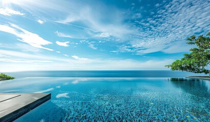 Wall Mural - Serene infinity pool overlooking the expansive ocean under a blue sky