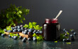 Blueberry jam and fresh berries with leaves.